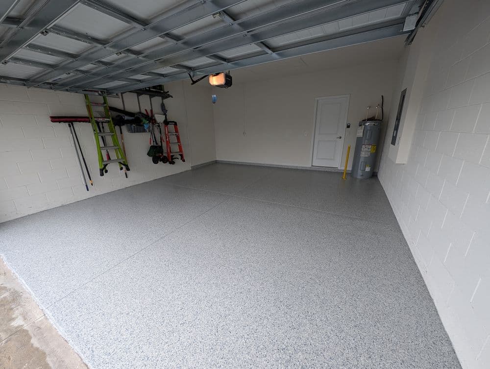 Clean and organized garage interior with epoxy floor coating and storage tools.