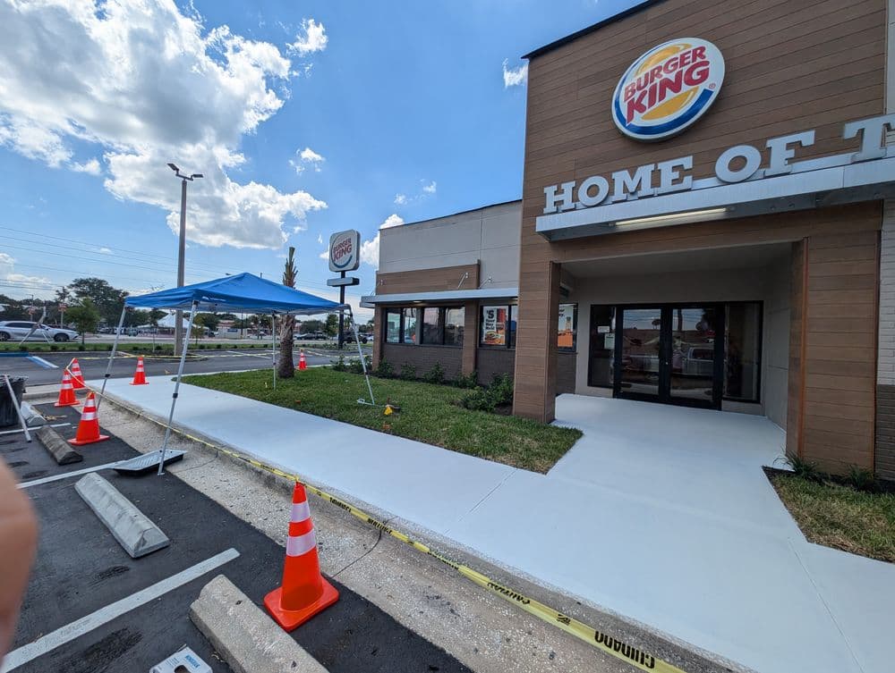 Burger King location with construction barriers and a tent outside the entrance.