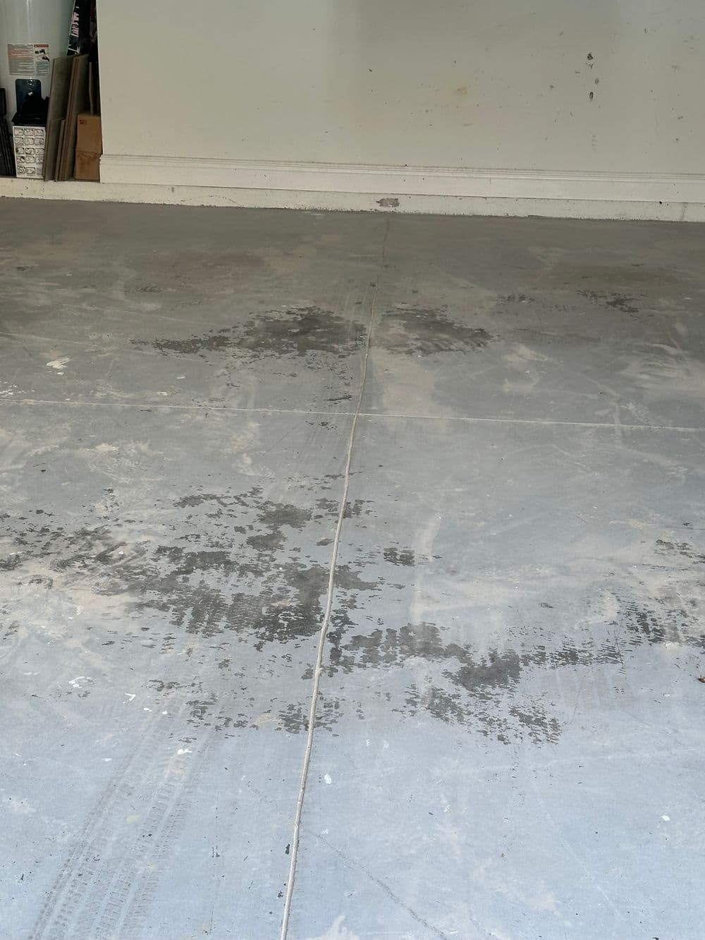 Concrete garage floor showing stains and marks, indicating wear and tear.